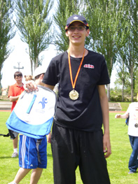 Un participantes nos enseña la medalla y la mochila ganada.