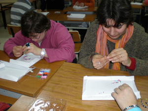 Algunos participantes mientras realizan el taller de abalorios.